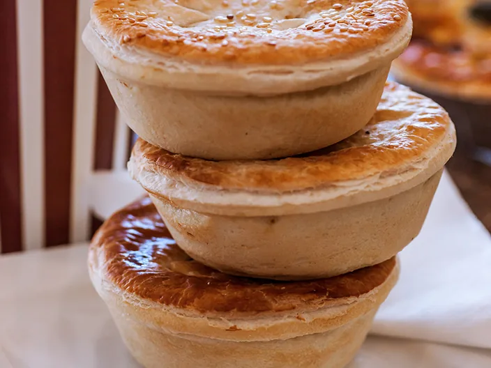Three glazed pies stacked one on another.
